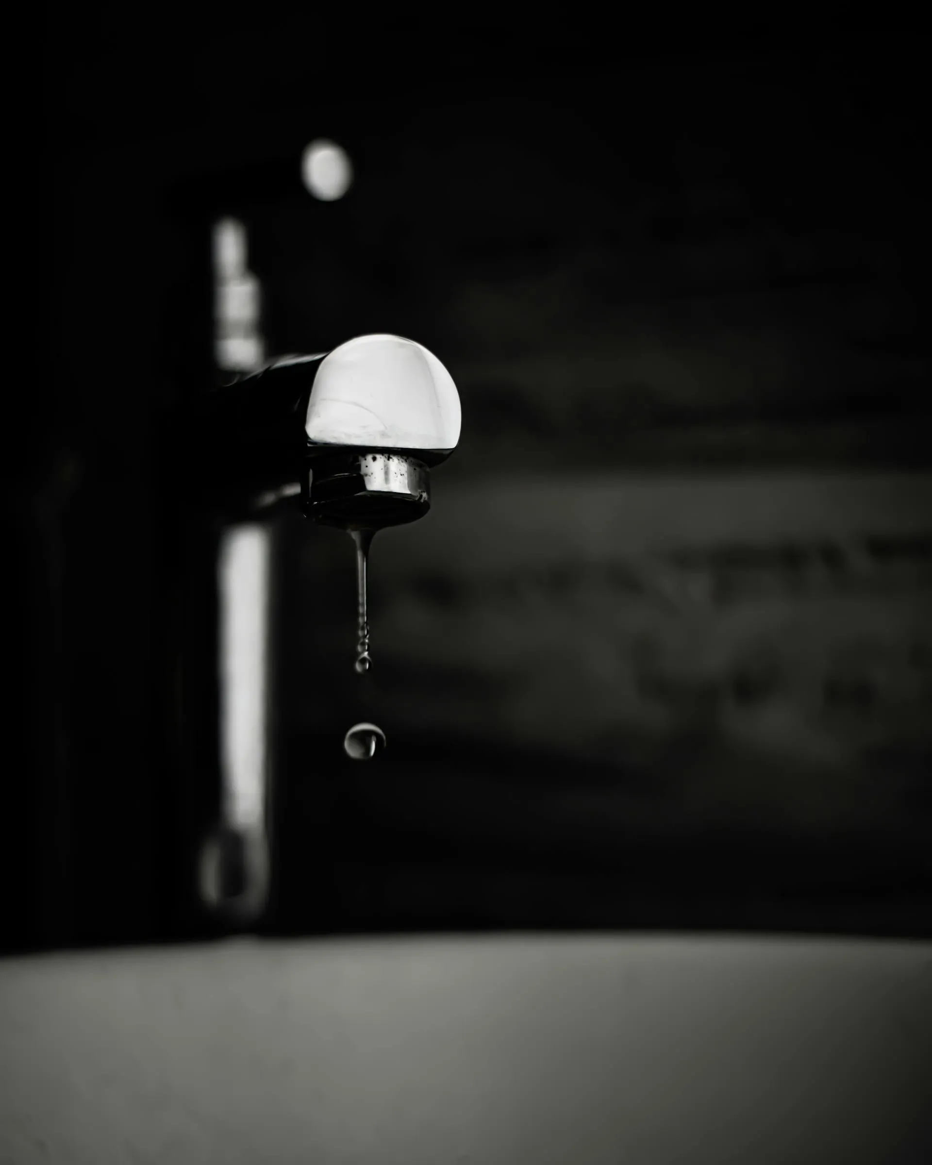 Tap with dropping water, a visual metaphor for technical debt when the tap is open and the puddle keeps coming back
